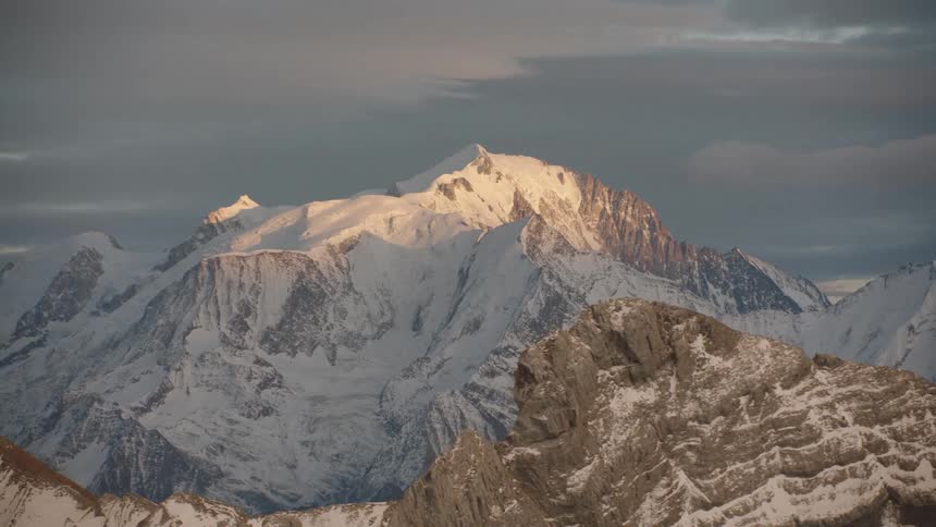 Aerial panorama of mountains and peaks covered in snow on a cloudy morning