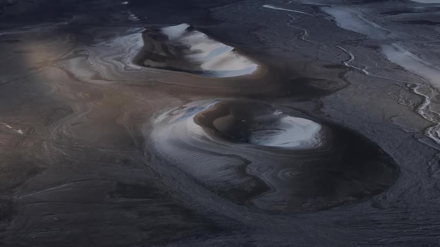 Aerial panorama of craters in a black desert