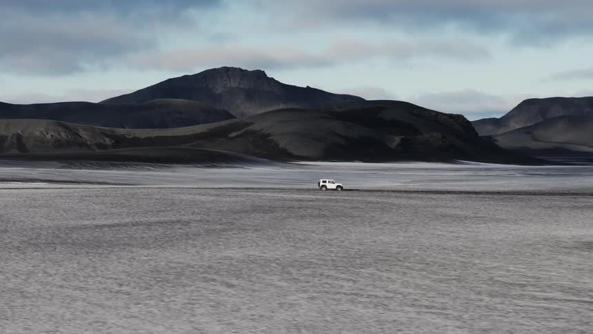 White jeep moving on a road in the middle of nowhere on a sunny day