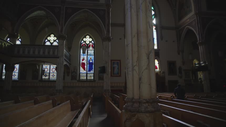 Man walking through the nave of a church