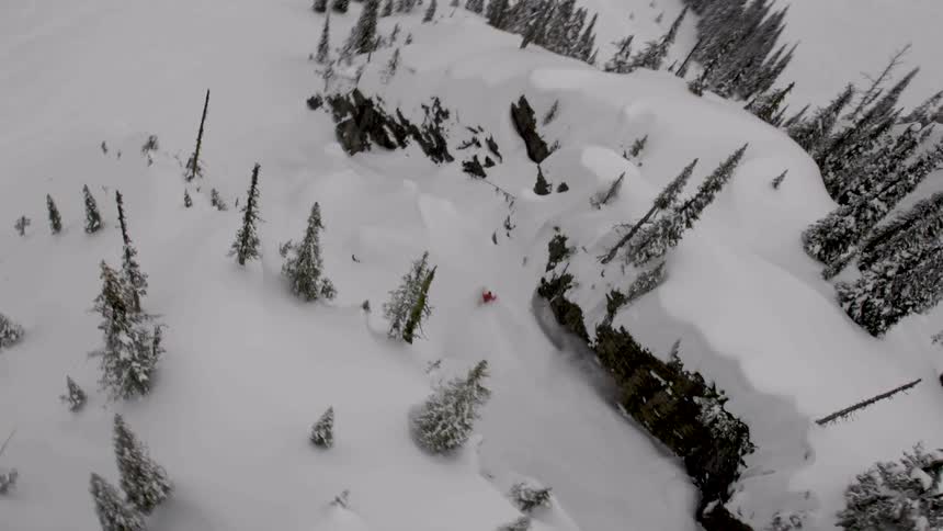 Snowboarder rides down a steep chute