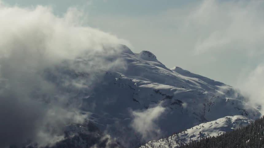 The clouds flow over the mountain