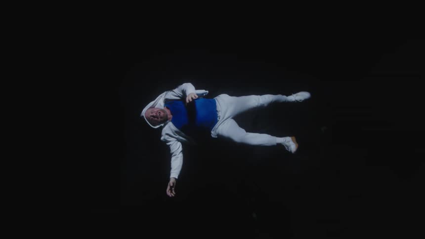 Man wearing a white hoodie and a blue tshirt falling into the void of darkness