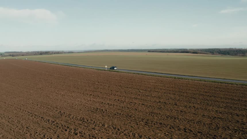 A moving car in a rural area at midday