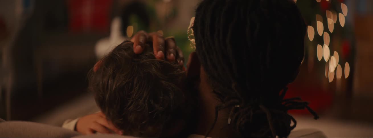 A father carrying his sleeping son on his lap