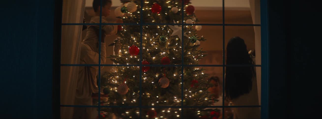 A family inside a house is decorating a christmas tree