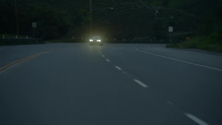 A car speeding on a road at dusk