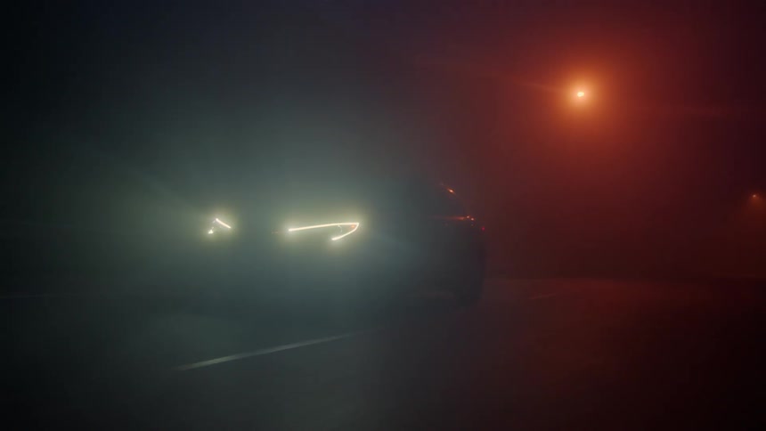 Front view of a vehicle moving on a street at night with fog