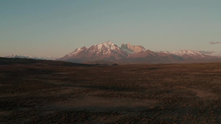 Aerial of desert with snowcapped mountains during daytime