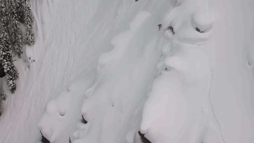 Professional Snowboarder rides a steep line