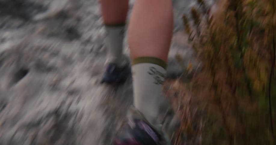 A person walking and climbing a rock to meet other people