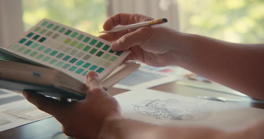 A person holding a color catalog for drawing
