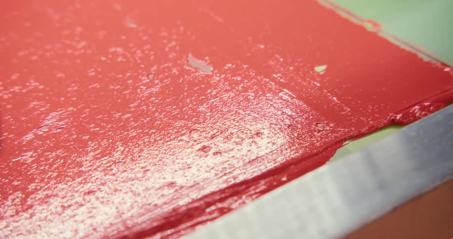 A machine is spreading paint on a surface