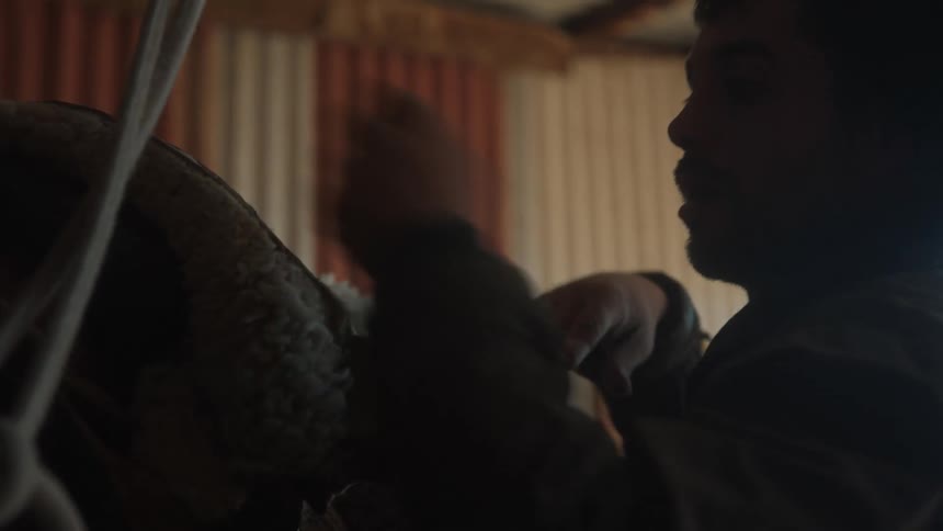 Handyman adjusts a saddle in the stable