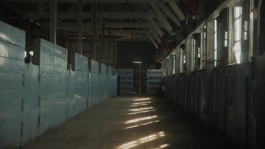 Internal view of a wooden ranch with solar reflections through the windows