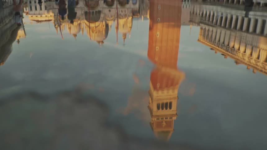 The city reflected in the water of a fountain