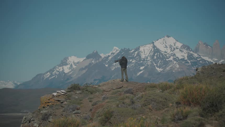 A photographer on top of a mountain photographing the landscape