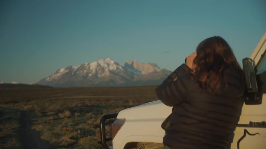 A woman observing the mountain with binoculars