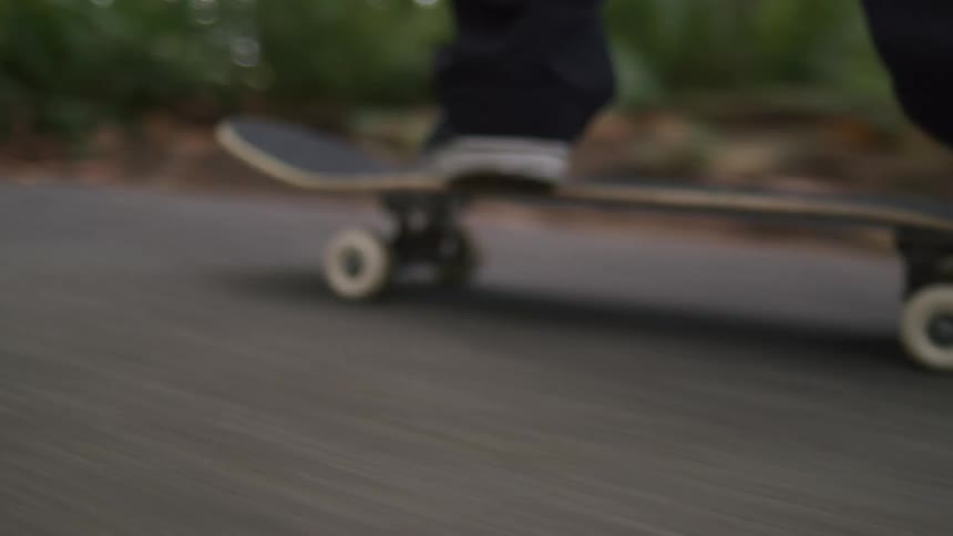 A person standing on a skateboard that is going fast
