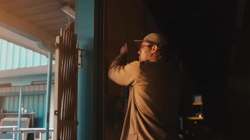 A man opens a metal door to a room filled with furniture
