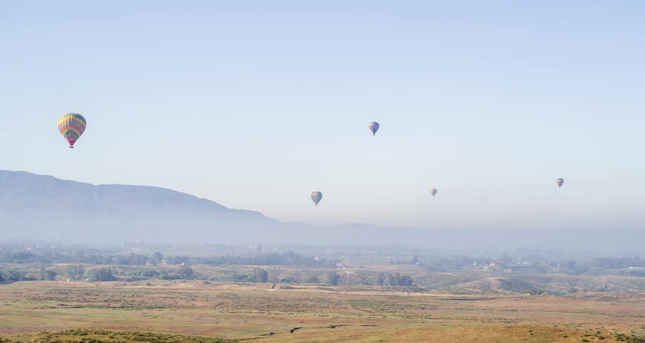 Hot air balloons floating over the countryside