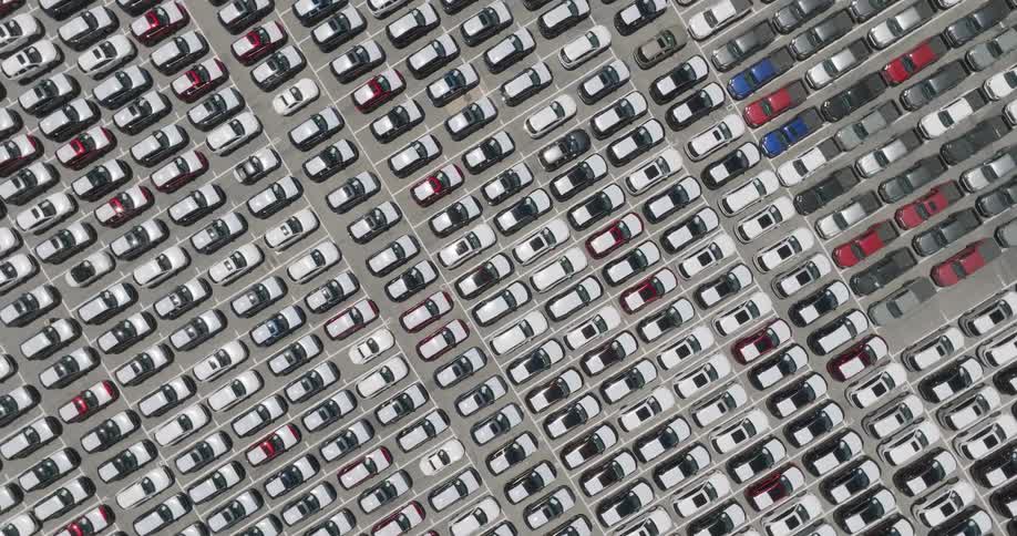 Panoramic aerial view of an environment with thousands of cars parked in a standardized manner