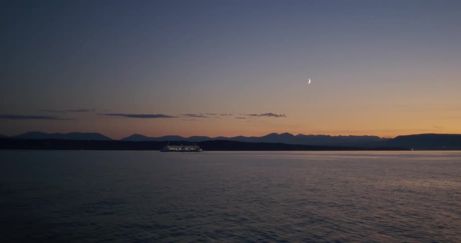Ferry on a lake at evening under the crescent moon