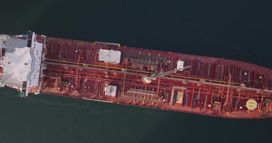 A small boat pulling a huge vessel