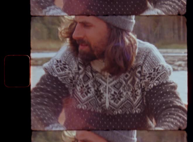 Close up portrait of man that rows a boat in a lake as the bright sun shines from the rear causing lens flare in the vintage camera while he is smiling and contemplating