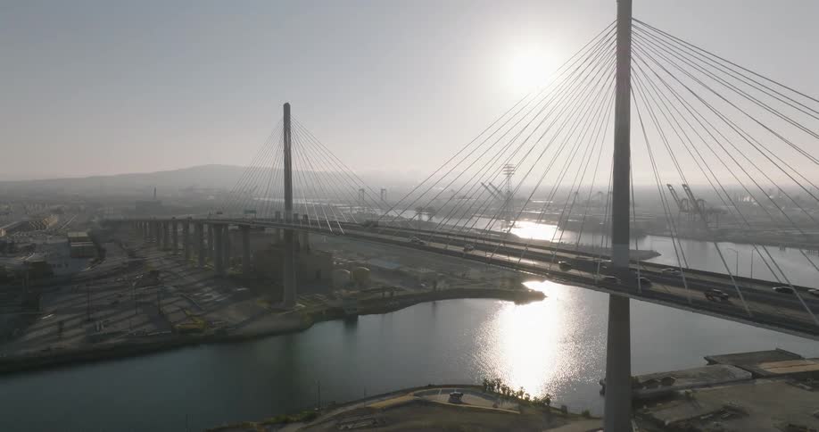 Aerial of suspension bridge over the river and sunny city
