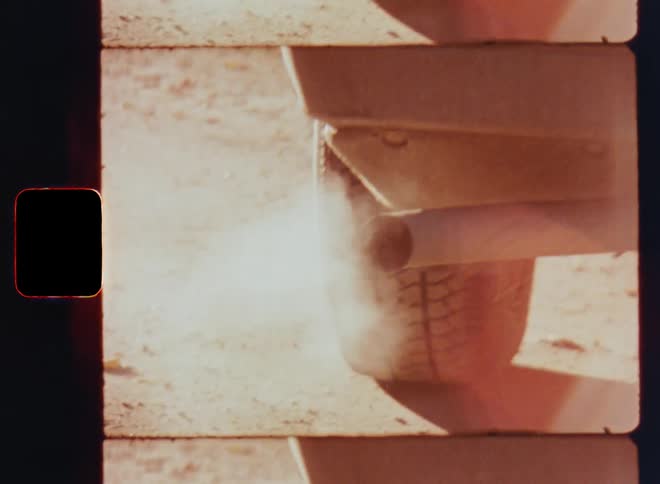 Old Super-8 film footage of dirty smoke or steam coming out of a parked cars exhaust on a sunny day as symbol for global warming caused by burning fossil fuels due to old technologies and diesel gasoline or petrol engines