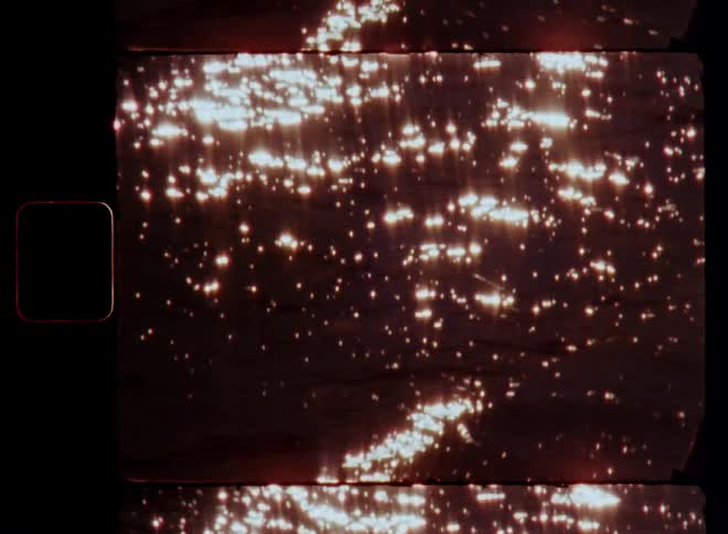 Vintage Super 8mm closeup of a calm moving sea or lake with a flickering sunlight reflection on the water surface as the waves roll in and move causing abstract and glaring light effect