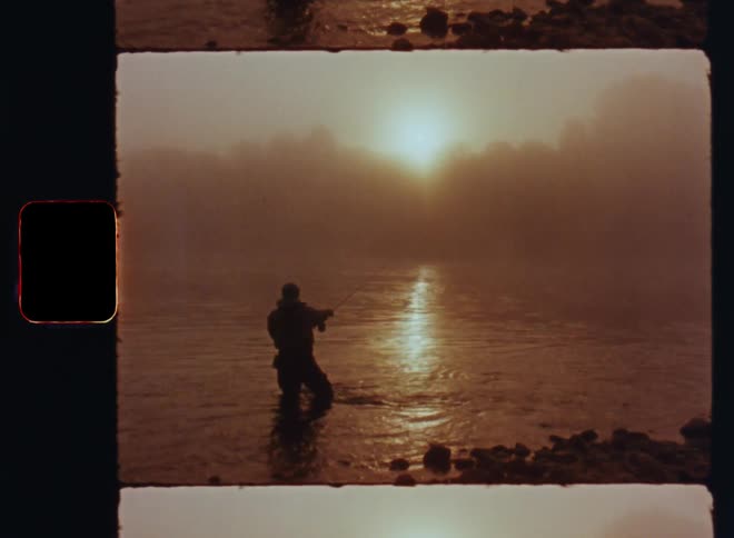 Man outdoors standing in a river fly fishing for salmon with a flyrod on a foggy day during dusk or dawn
