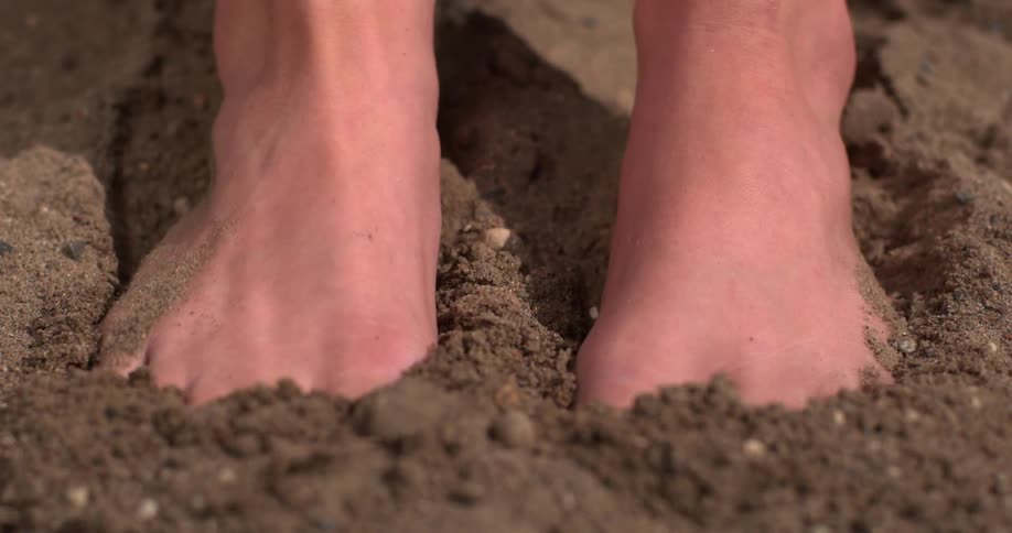 Person pushing their feet into sand