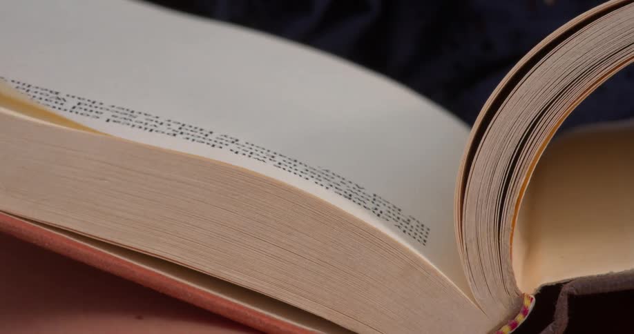 A person is turning pages of a book