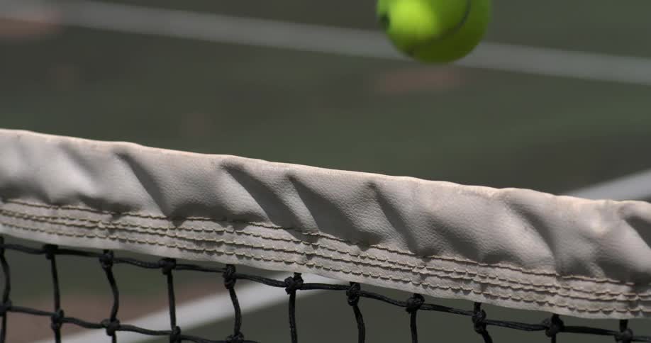 A tennis ball bounces off a net