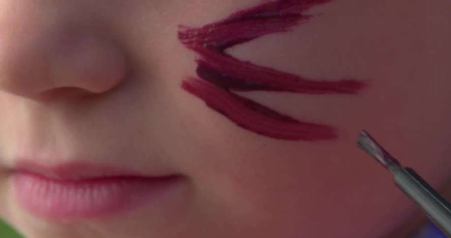 A woman puts paint on her face