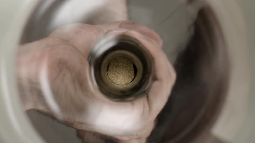 A person removes a cork from a jar