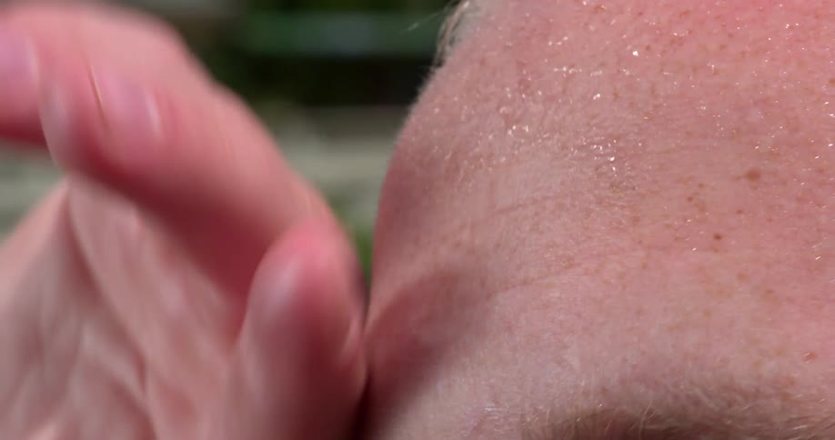 A man wipes the sweat off his brow
