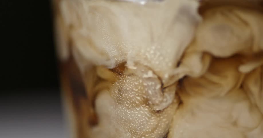 Milk is poured into a dark drink