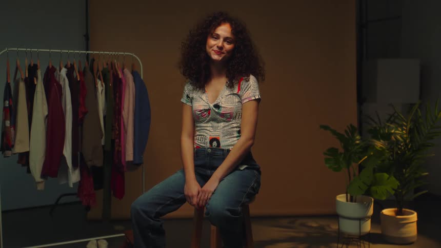 A woman sitting on a wooden bench at a photo shoot