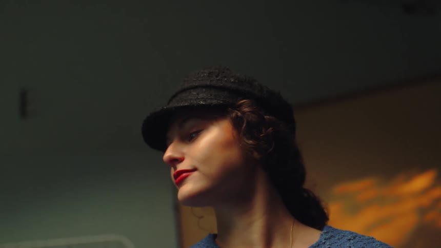 Young woman modeling a fancy hat in the dressing room