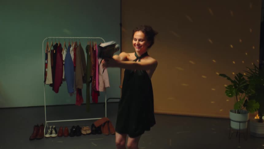 Young woman films herself wearing a dress