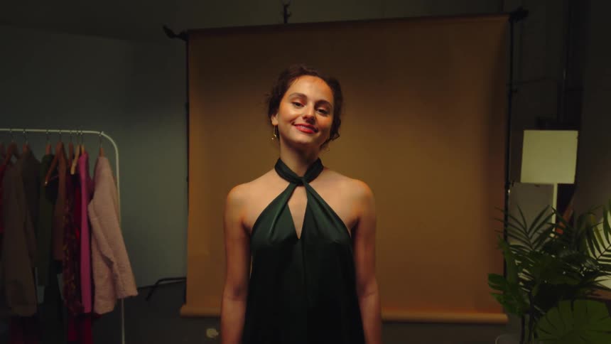 A young woman in a dark green party dress