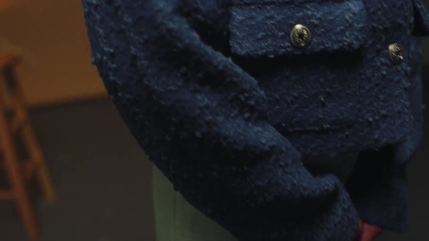 Closeup of a woman wearing a blue wool and linen coat