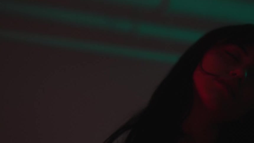 Young woman dances under red lights