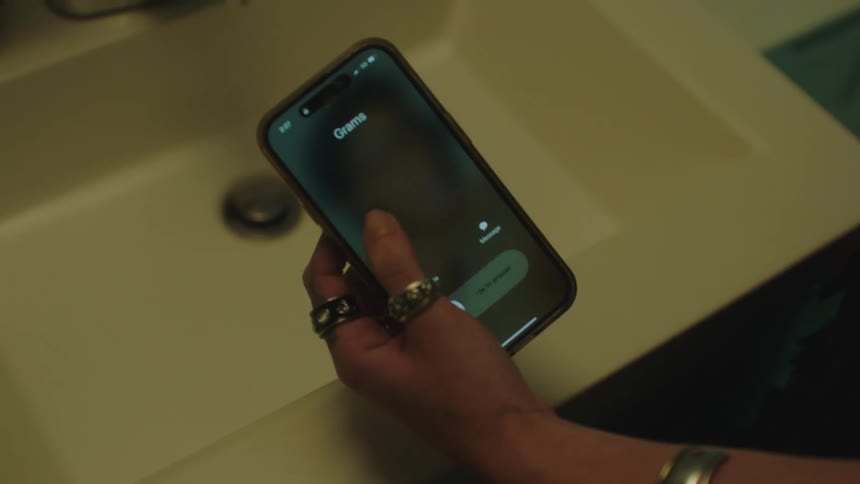 A cell phone calling on top of the bathroom sink