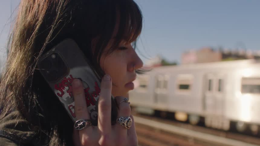 A woman at the train station talking on her cell phone