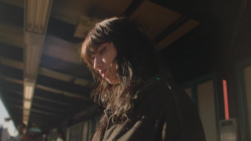 A lady standing on a walkway beside a building and talking