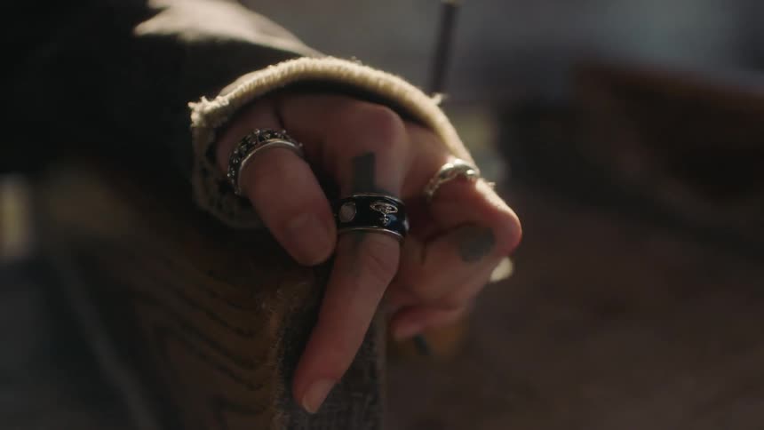 Female human hands wearing silver rings tumbling on a wooden piece of furniture